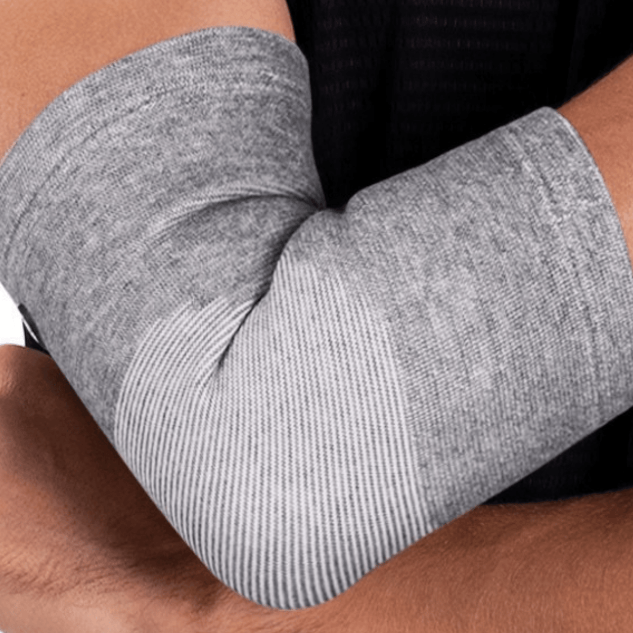 A woman wearing a Thermo Elbow Sleeve for recovery 2