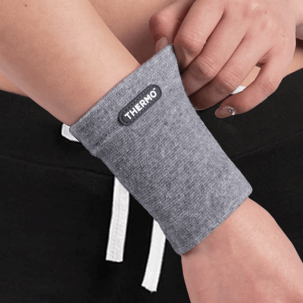 A woman wearing a Thermo Wrist Sleeve for recovery