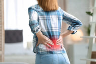 A woman who needs to learn how to relieve back pain fast at home.