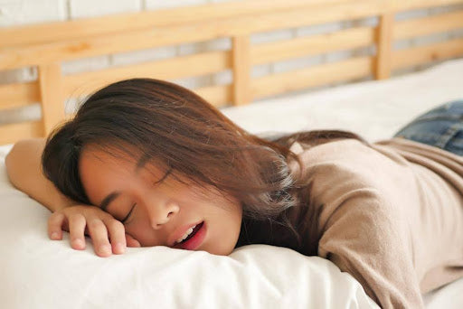 A woman sleeping wearing a recovery sleeve.